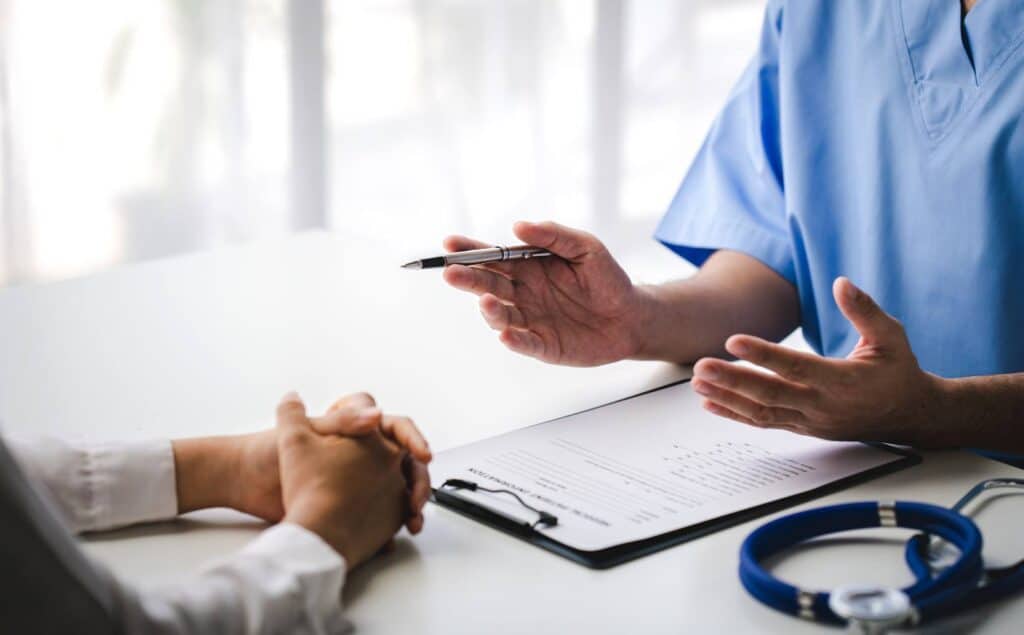 Doctor talking through TMS insurance coverage details with a patient.