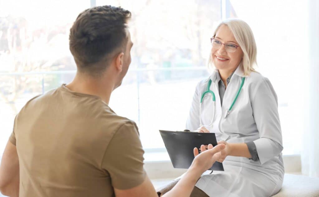 Doctor and patient discussing TMS insurance coverage in a medical consultation room.